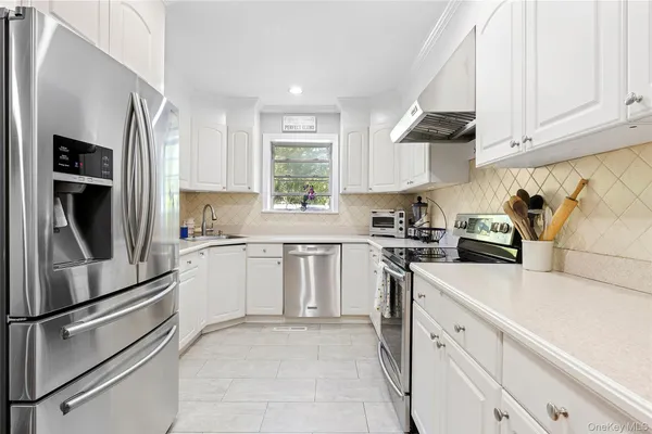 a kitchen with granite countertop white cabinets and white appliances