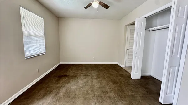 an empty room with windows and closet