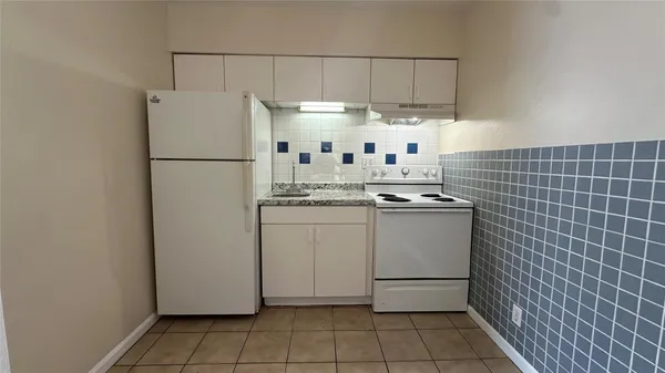 a kitchen with cabinets a refrigerator and a stove