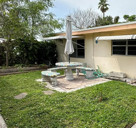 a view of a house with backyard and sitting area