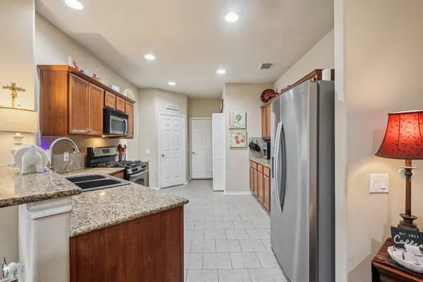 a kitchen with stainless steel appliances granite countertop a refrigerator stove and sink