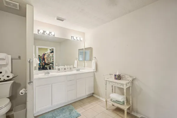 a bathroom with a double vanity sink toilet and shower