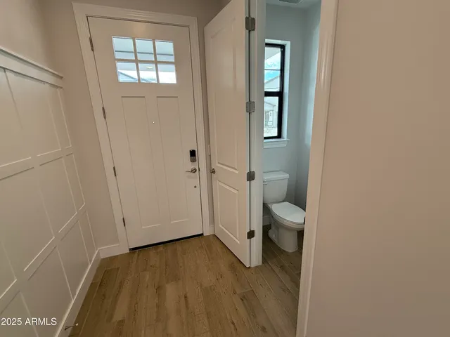 a view of a hallway with wooden floor and staircase