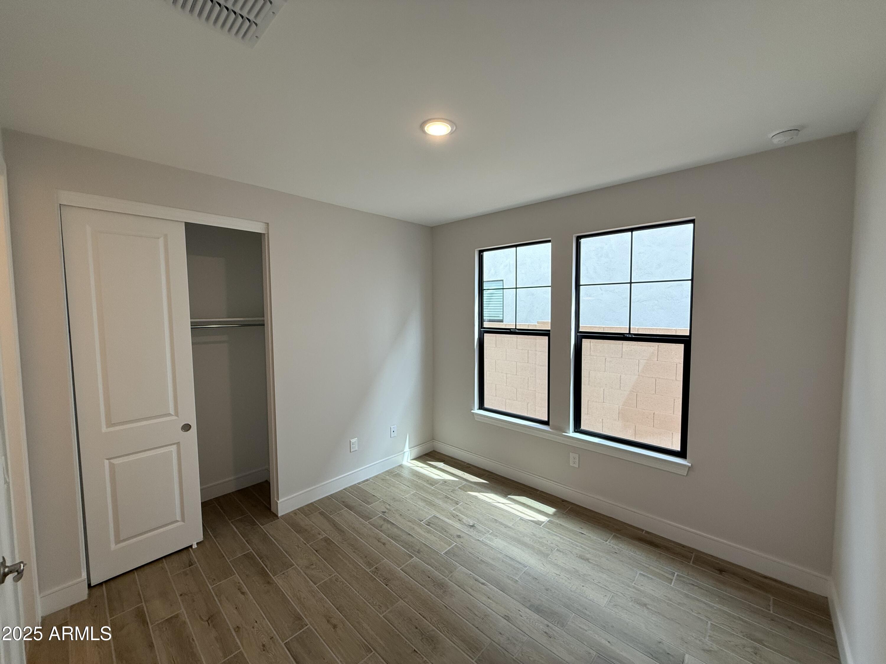 2430 West Los Arboles Place Chandler, AZ 85224 - Photo 15 of 41 an empty room with wooden floor and windows