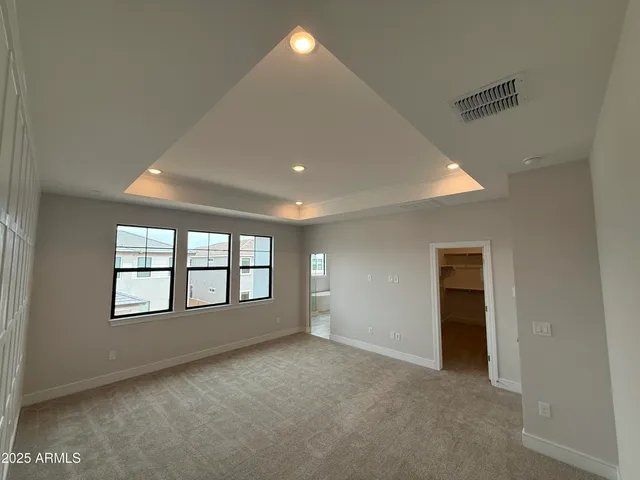 an empty room with windows and ceiling fan