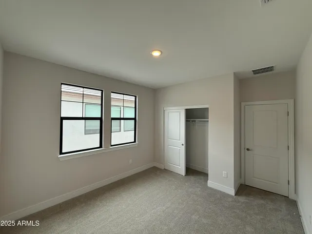 an empty room with windows and closet