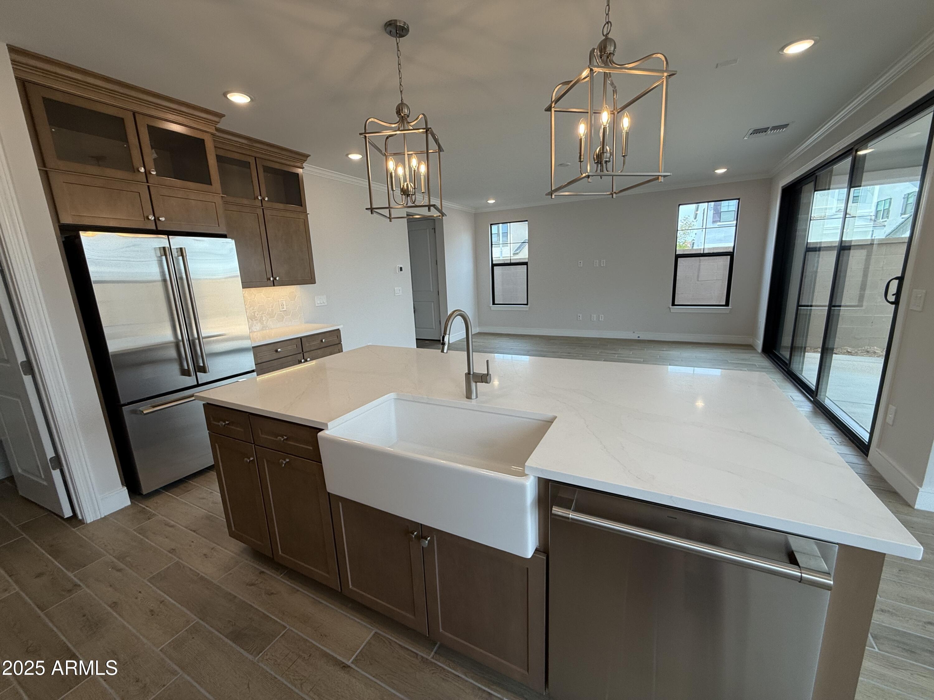 2430 West Los Arboles Place Chandler, AZ 85224 - Photo 7 of 41 a kitchen with stainless steel appliances a sink dishwasher a refrigerator and a large mirror with wooden floor