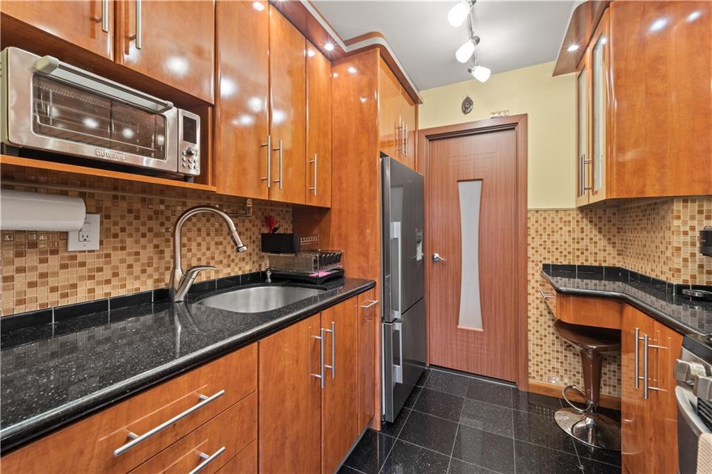 1625 Emmons Avenue, Unit 1R Brooklyn, NY 11235 - Photo 4 of 25 a kitchen with granite countertop stainless steel appliances a sink stove and refrigerator