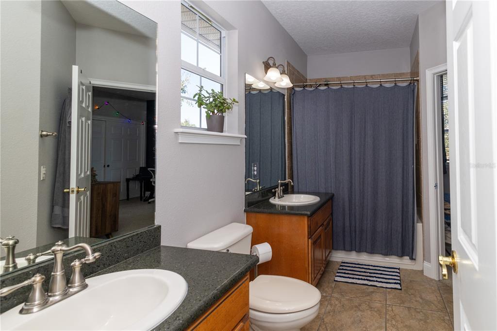 3305 Schoolhouse Road St. Cloud, FL 34773 - Photo 47 of 83 a bathroom with a granite countertop toilet sink and mirror