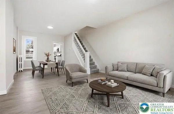 a living room with furniture and a dining table with wooden floor