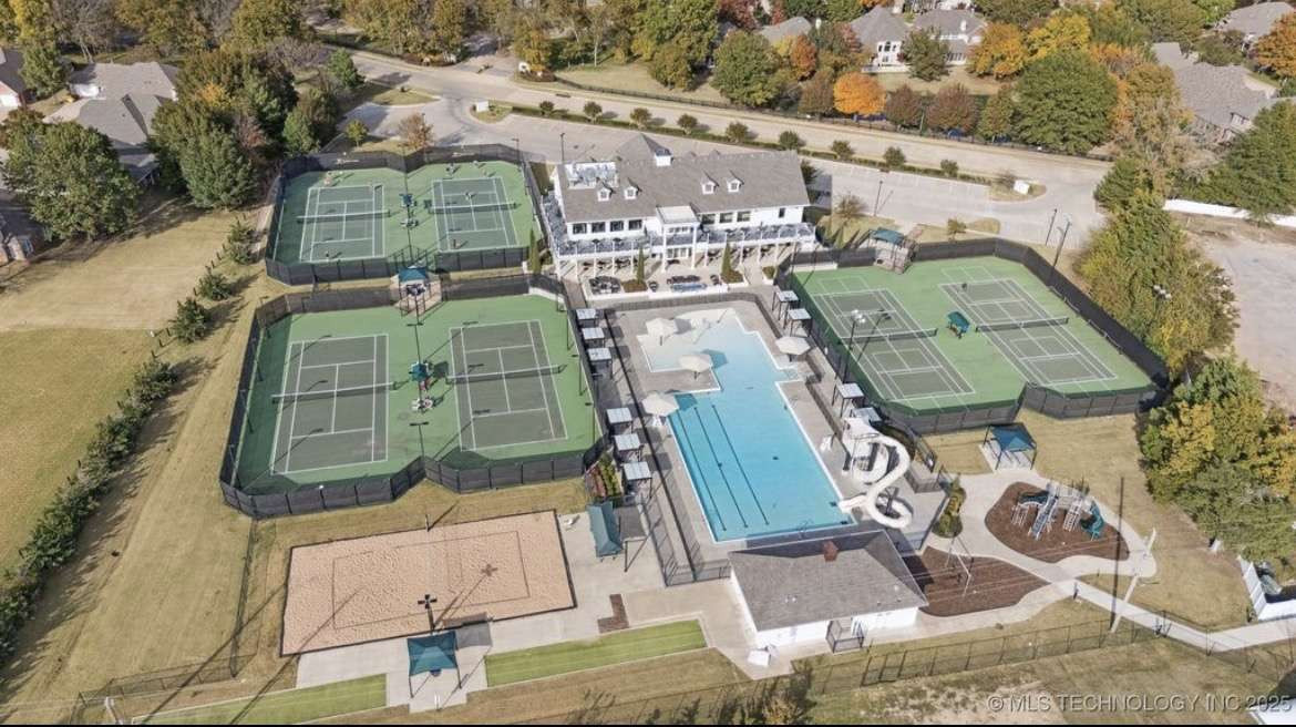 115 South Forest Ridge Boulevard Broken Arrow, OK 74014 - Photo 48 of 50 Community amenities featuring multiple tennis courts, a large outdoor swimming pool with water slides, a clubhouse building, a sand volleyball court, and a playground area