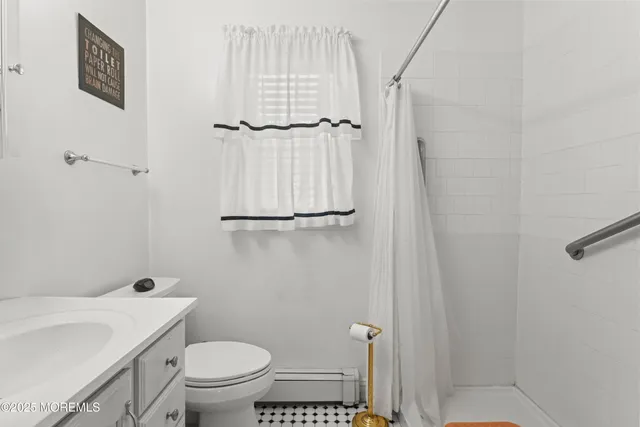 a bathroom with a granite countertop toilet and a sink