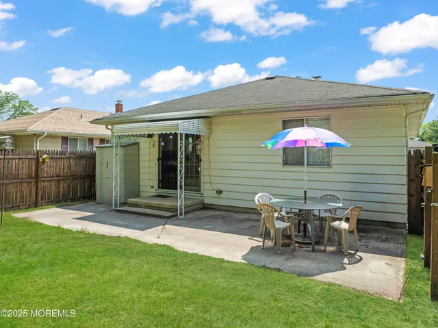 a view of a patio with a table and chairs under an umbrella