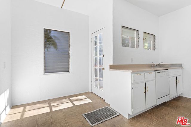 a view of kitchen with a sink cabinets and window