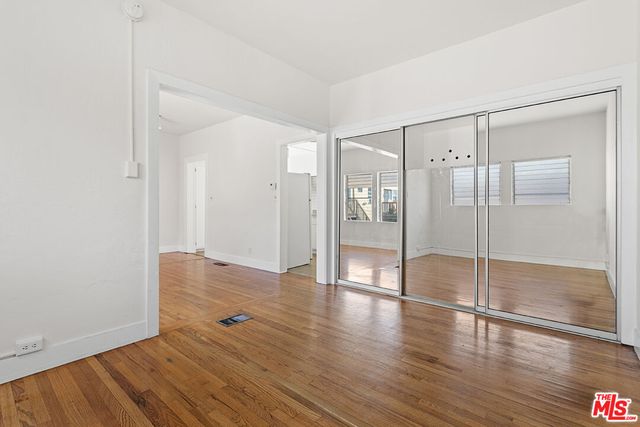 a big room with wooden floor and sliding glass door
