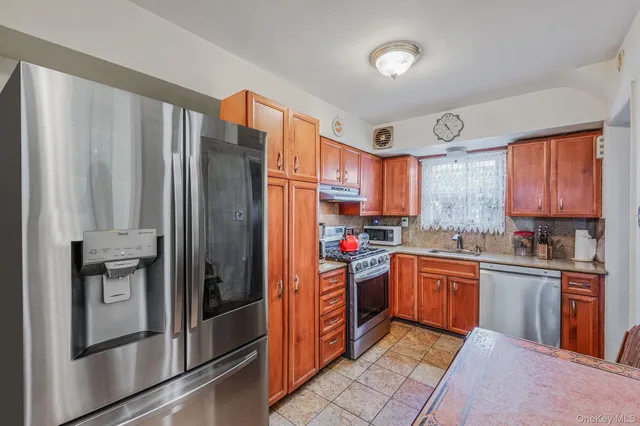 a kitchen with stainless steel appliances granite countertop a refrigerator and a stove top oven