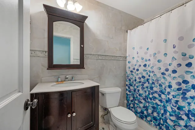 a bathroom with a toilet a sink and a mirror