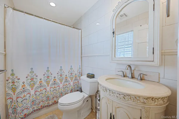 a bathroom with a sink a toilet and a mirror