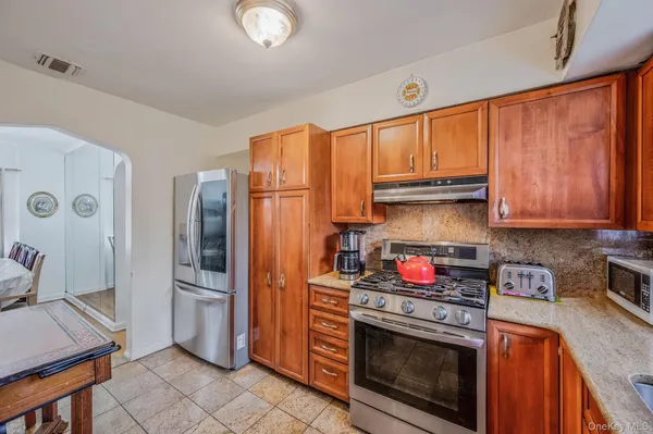 a kitchen with stainless steel appliances granite countertop a stove a refrigerator and a sink