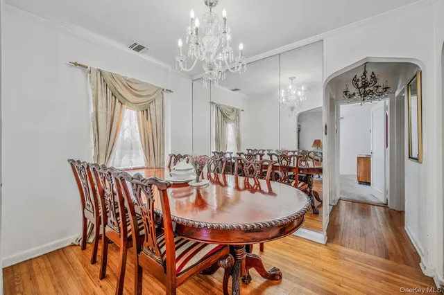 a dining room with furniture a chandelier and wooden floor