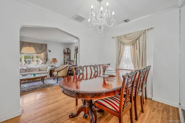 a dining room with furniture a chandelier and wooden floor