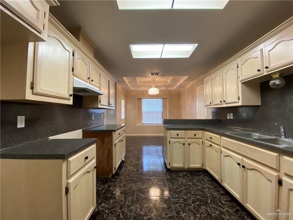 2207 Paseo Encantado Mission, TX 78572 - Photo 18 of 44 a kitchen with stainless steel appliances granite countertop a sink a stove and cabinets