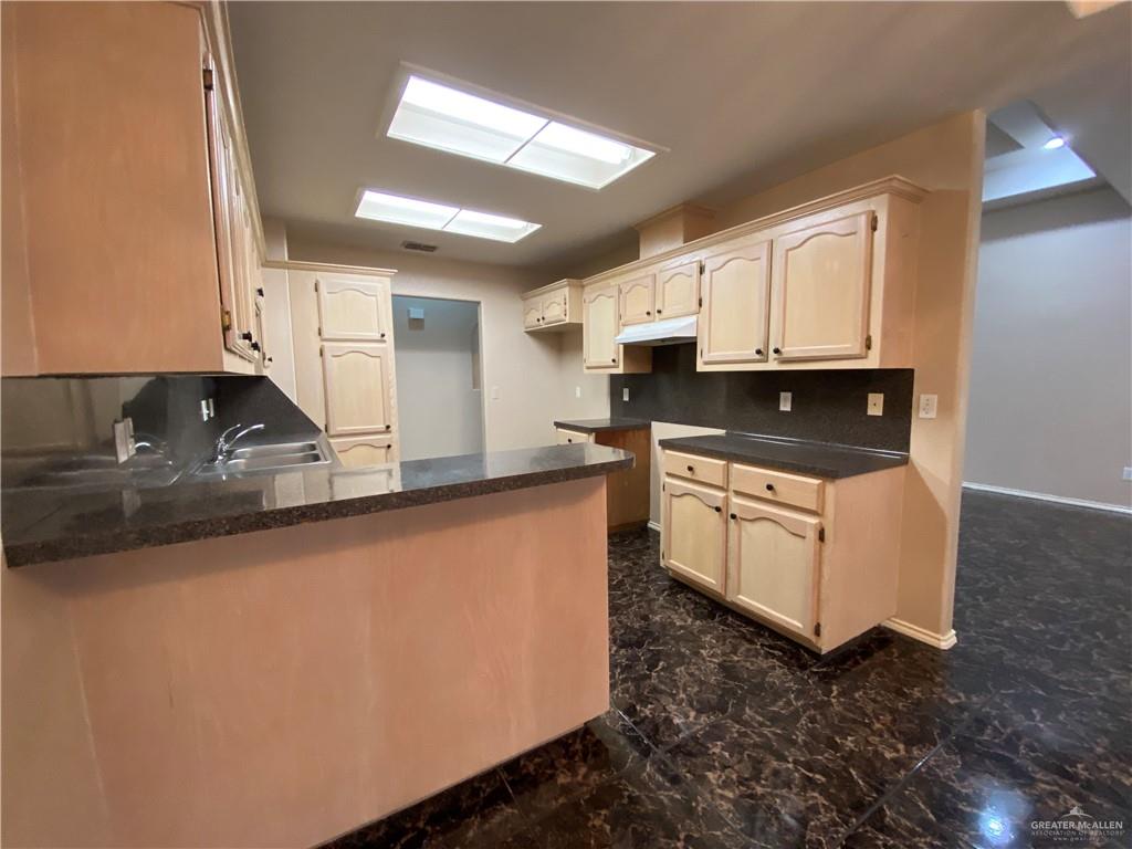 2207 Paseo Encantado Mission, TX 78572 - Photo 23 of 44 a kitchen with stainless steel appliances granite countertop a sink a stove and a refrigerator