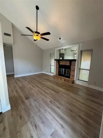 a view of empty room with wooden floor and ceiling fan