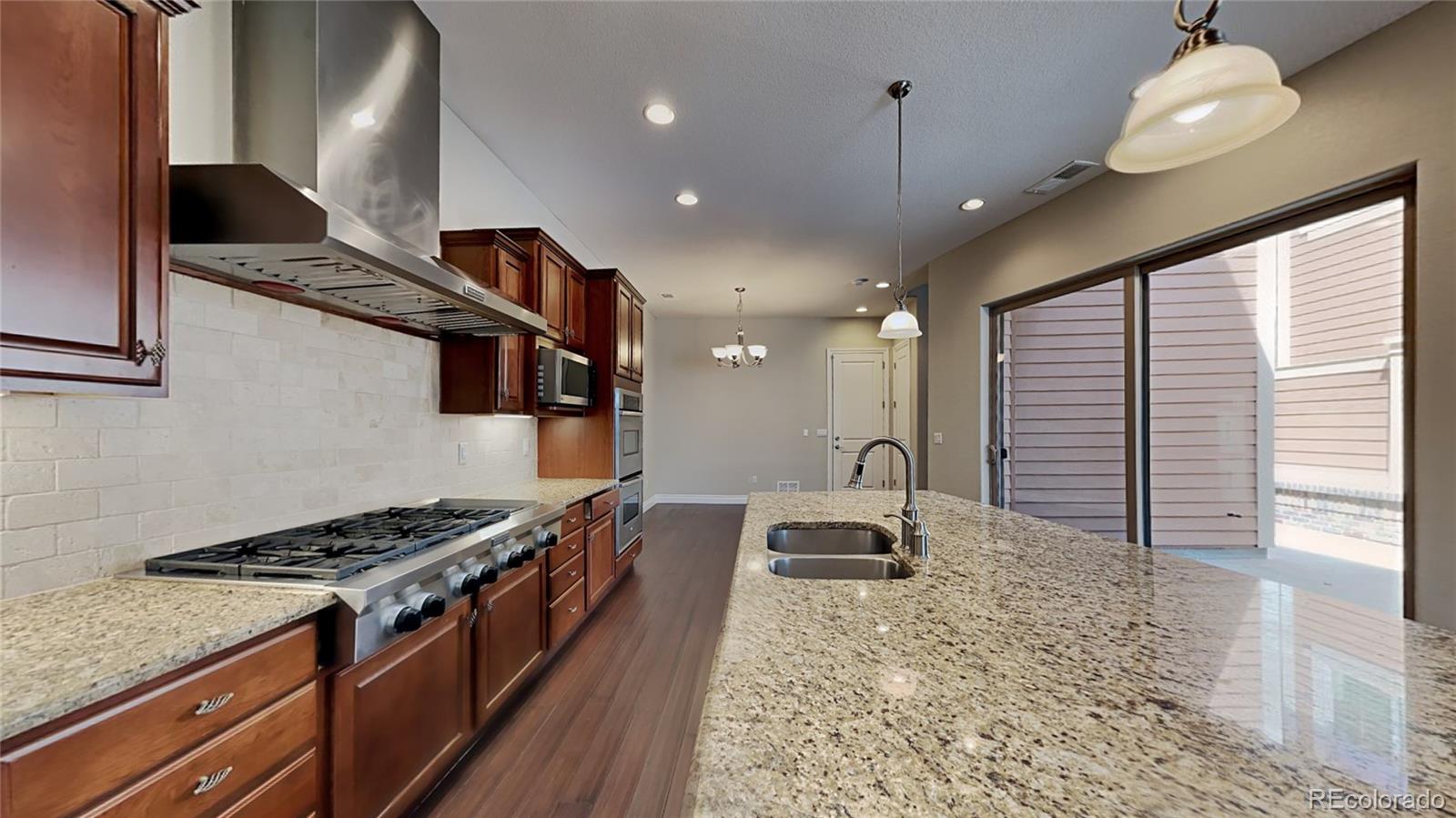 9237 Mornington Way Lone Tree, CO 80124 - Photo 8 of 24 a kitchen with stainless steel appliances granite countertop a stove and a sink