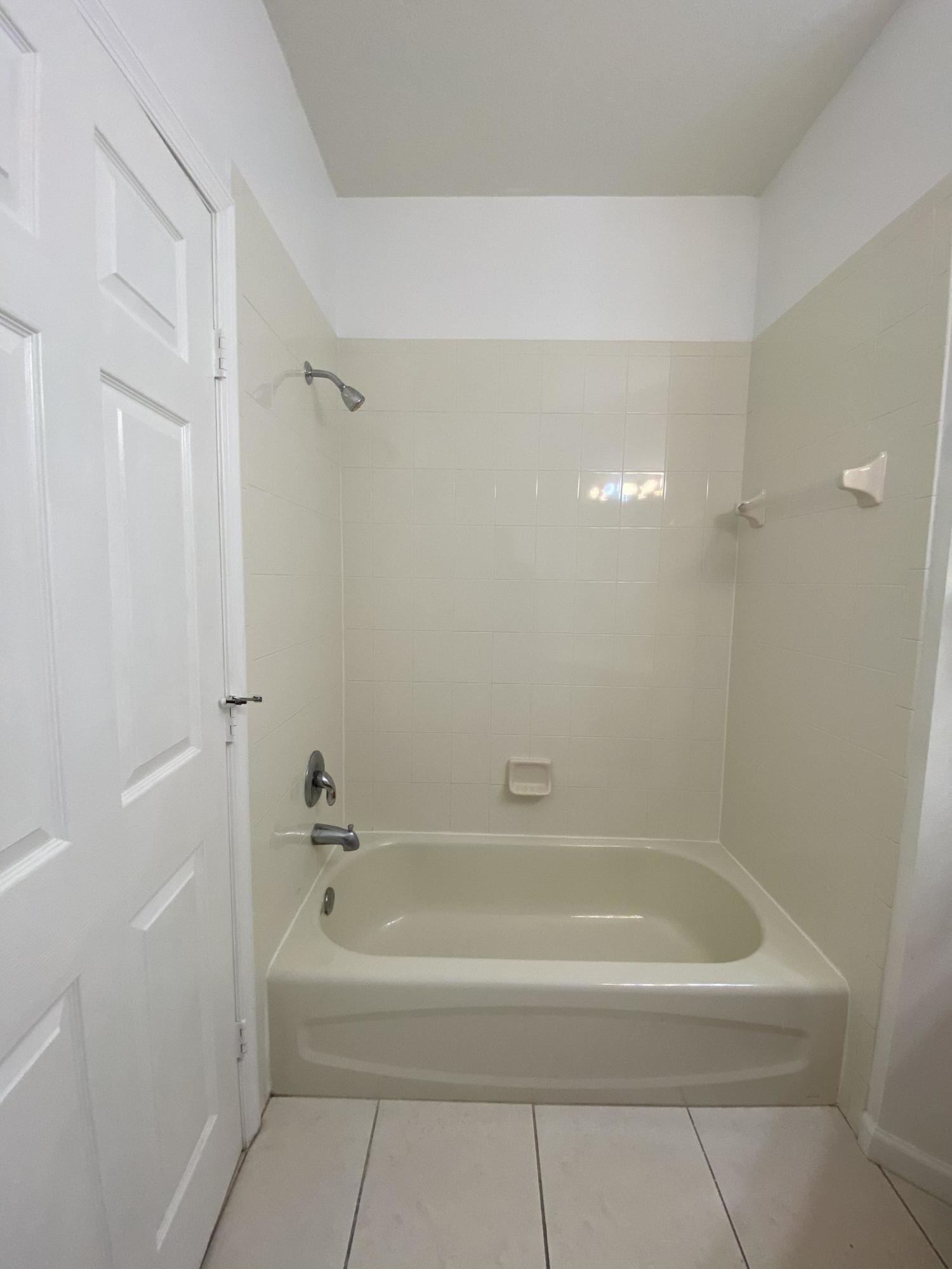 8377 Mulligan Circle, Unit SIDE B Port St. Lucie, FL 34986 - Photo 14 of 17 a spacious bathroom with a bathtub and shower