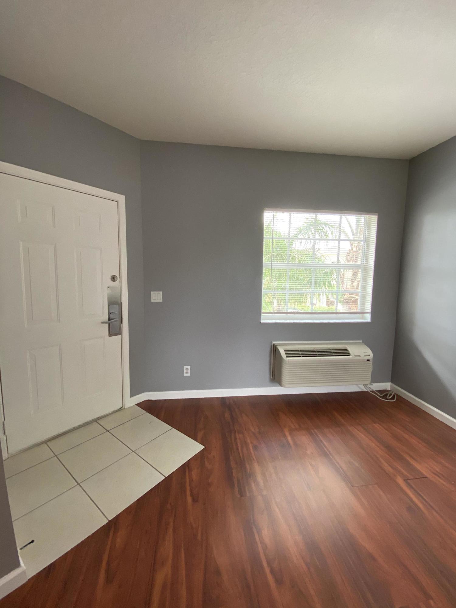 8377 Mulligan Circle, Unit SIDE B Port St. Lucie, FL 34986 - Photo 16 of 17 an empty room with wooden floor and windows