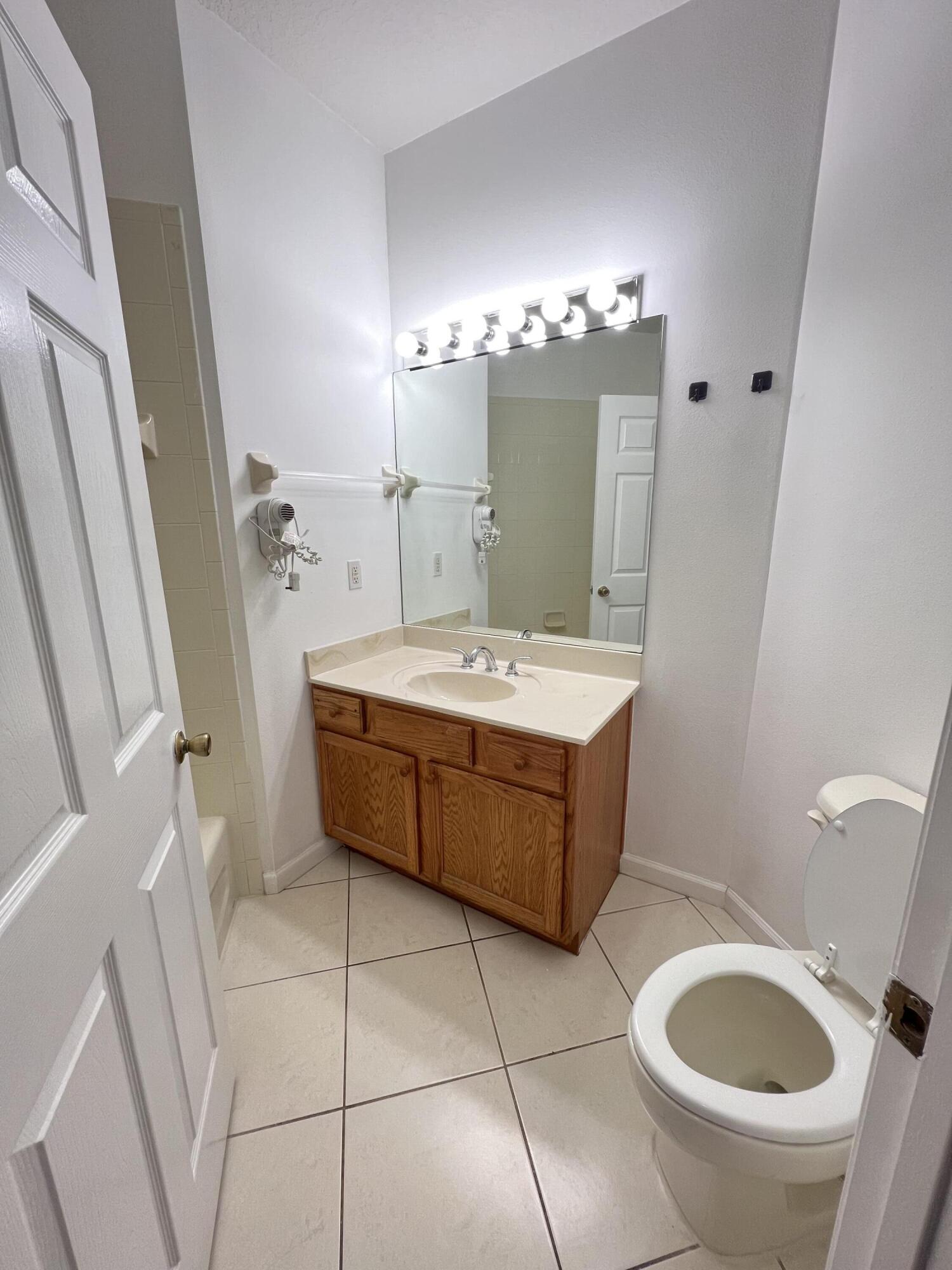 8377 Mulligan Circle, Unit SIDE B Port St. Lucie, FL 34986 - Photo 4 of 17 a bathroom with a bathtub sink and mirror