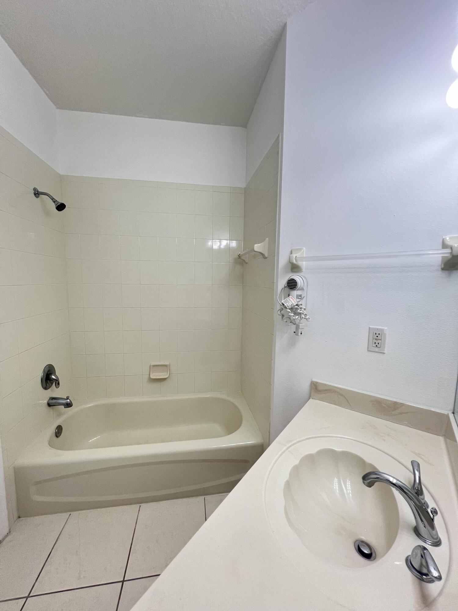 8377 Mulligan Circle, Unit SIDE B Port St. Lucie, FL 34986 - Photo 6 of 17 a bathroom with a tub and a sink