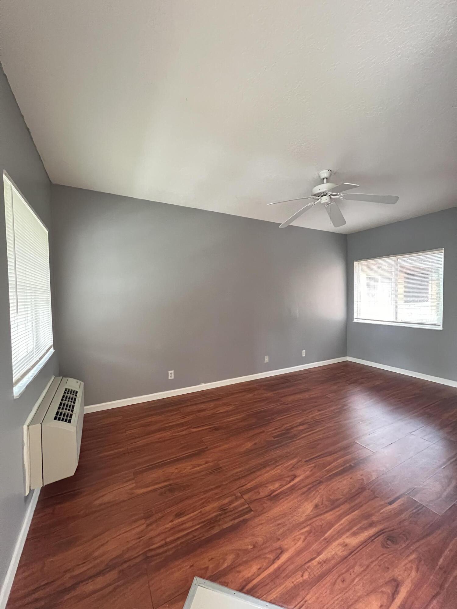 8377 Mulligan Circle, Unit SIDE B Port St. Lucie, FL 34986 - Photo 9 of 17 a view of an empty room with wooden floor and a window