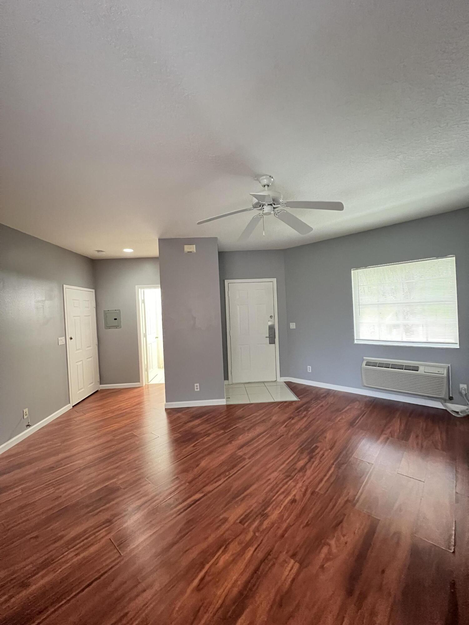 8377 Mulligan Circle, Unit SIDE B Port St. Lucie, FL 34986 - Photo 10 of 17 a view of empty room with wooden floor and fan
