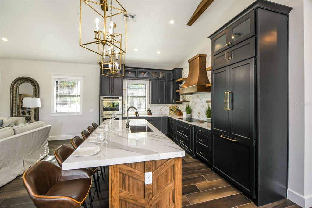 340 Jackson Drive Sarasota, FL 34236 - Photo 20 of 100 a kitchen with stainless steel appliances granite countertop a refrigerator a sink dishwasher a stove and a dining table with wooden floor