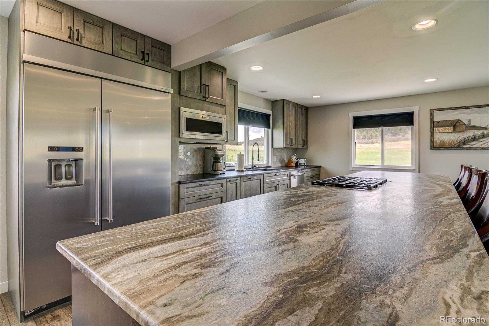 4531 East Best Road Larkspur, CO 80118 - Photo 5 of 49 a large kitchen with granite countertop a refrigerator and a sink