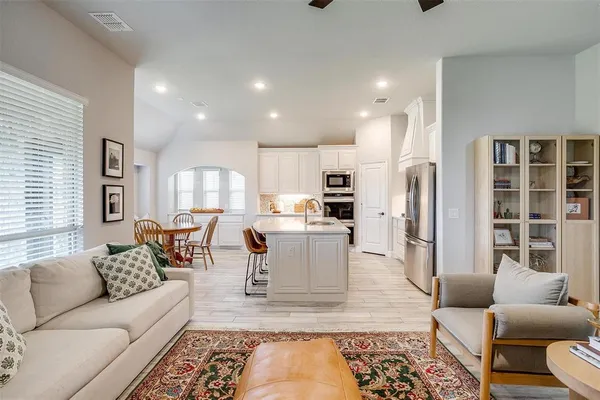 a living room with furniture wooden floor and a large window