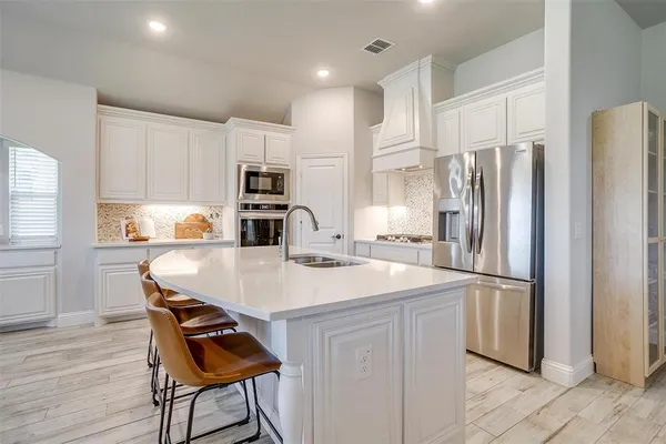 a kitchen with stainless steel appliances granite countertop a refrigerator and a stove top oven