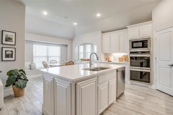 a kitchen with stainless steel appliances granite countertop a sink and cabinets