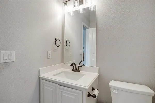 a bathroom with a sink toilet and mirror