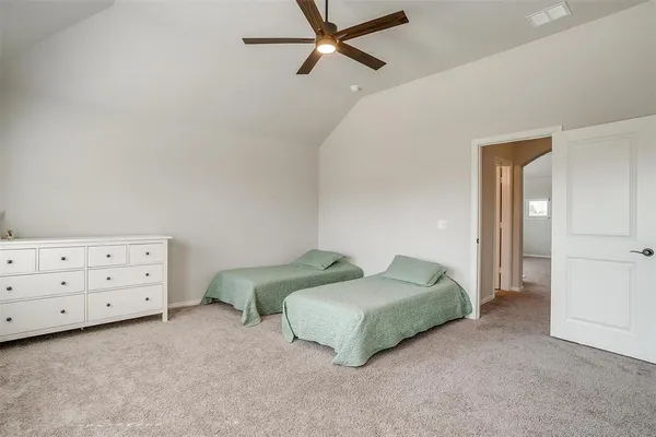 a spacious bedroom with a bed and a dresser