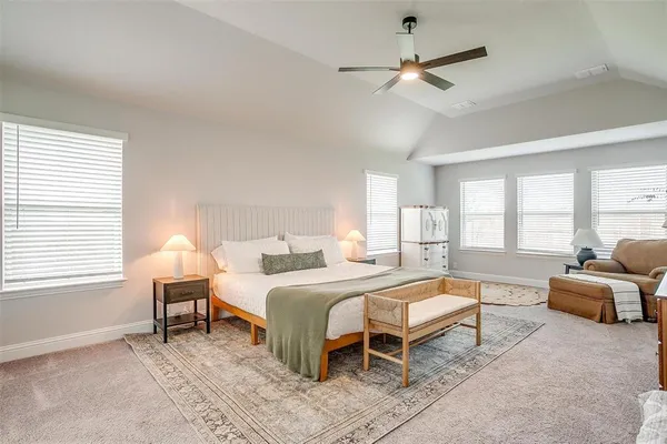 a bedroom with a bed a chandelier and a couch