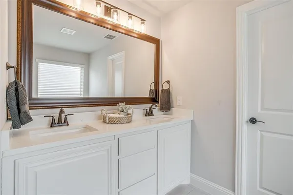 a bathroom with a double vanity sink and a mirror