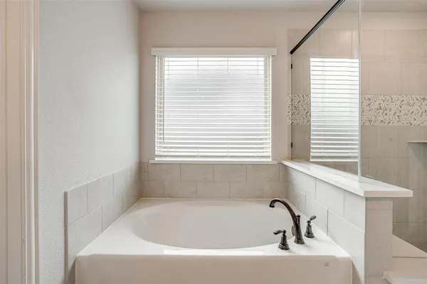 a white bath tub sitting in a bathroom next to a window