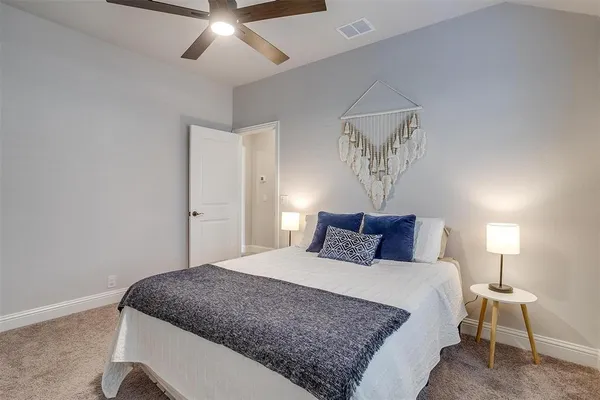a bedroom with a large bed and a chandelier
