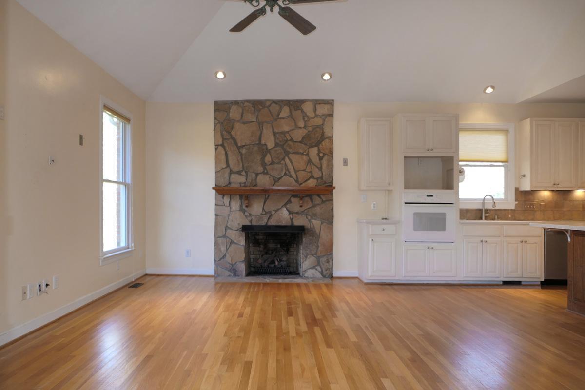 5330 Foxlair Road Chapel Hill, NC 27516 - Photo 14 of 43 an empty room with wooden floor a fireplace and windows