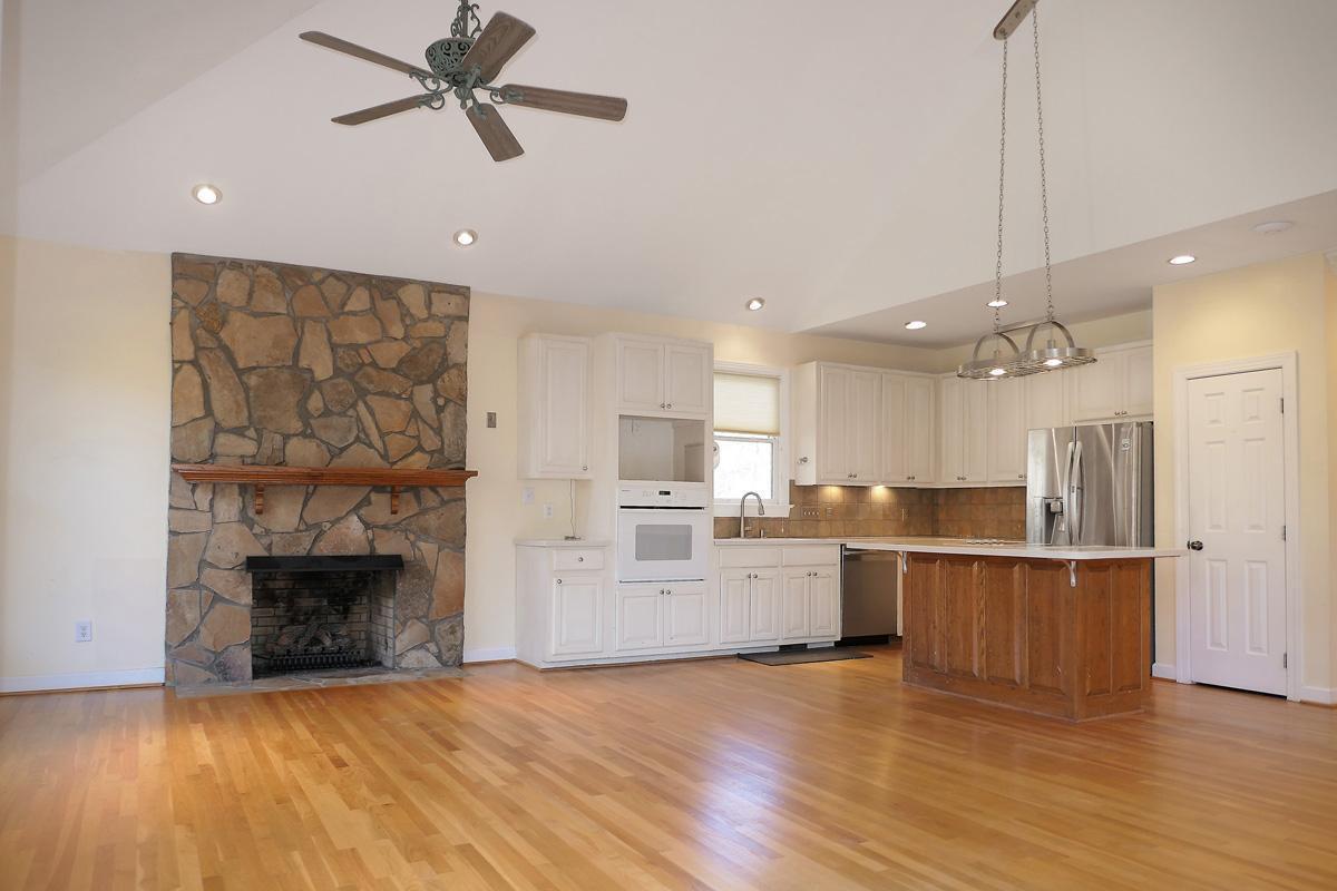 5330 Foxlair Road Chapel Hill, NC 27516 - Photo 19 of 43 a large kitchen with cabinets wooden floor and a fireplace