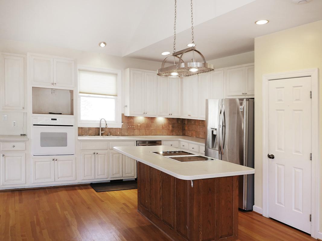 5330 Foxlair Road Chapel Hill, NC 27516 - Photo 20 of 43 a kitchen with stainless steel appliances granite countertop a refrigerator a sink dishwasher a stove and white cabinets with wooden floor