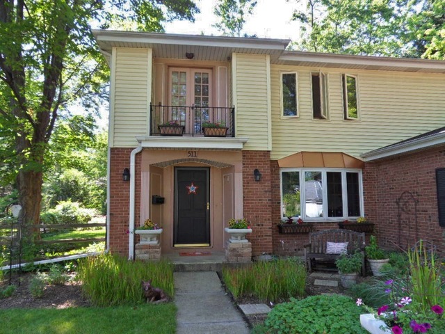 511 Post Road St. Charles, IL 60174 - Photo 3 of 25 a view of a house with brick walls and a yard with potted plants